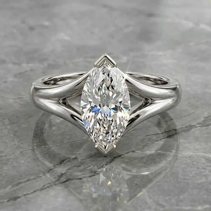 2 carat lab-grown marquise diamond split shank solitaire engagement ring displayed on stone surface.