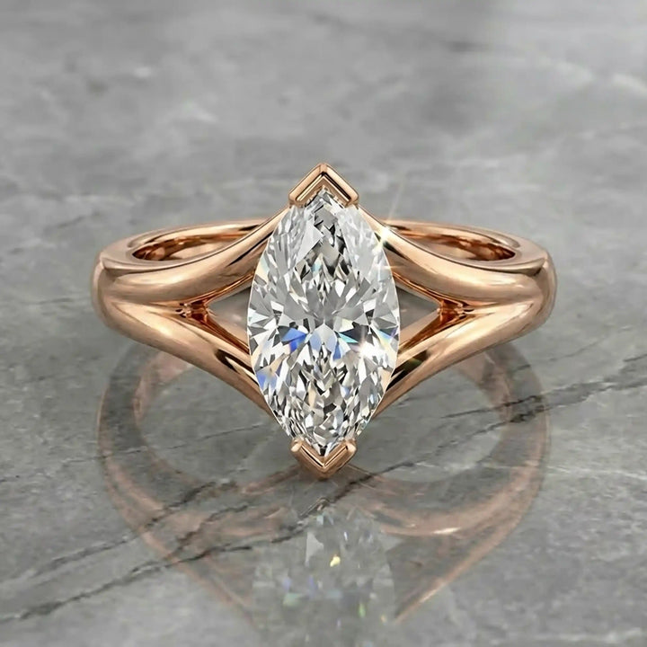 2 carat lab-grown marquise diamond split shank solitaire engagement ring displayed on stone surface.