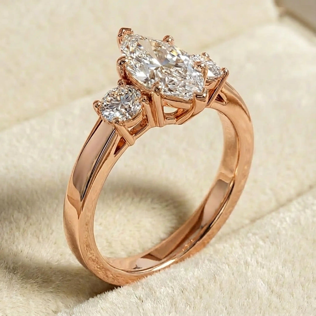 Marquise three-stone lab-grown diamond engagement ring displayed on soft fabric.
