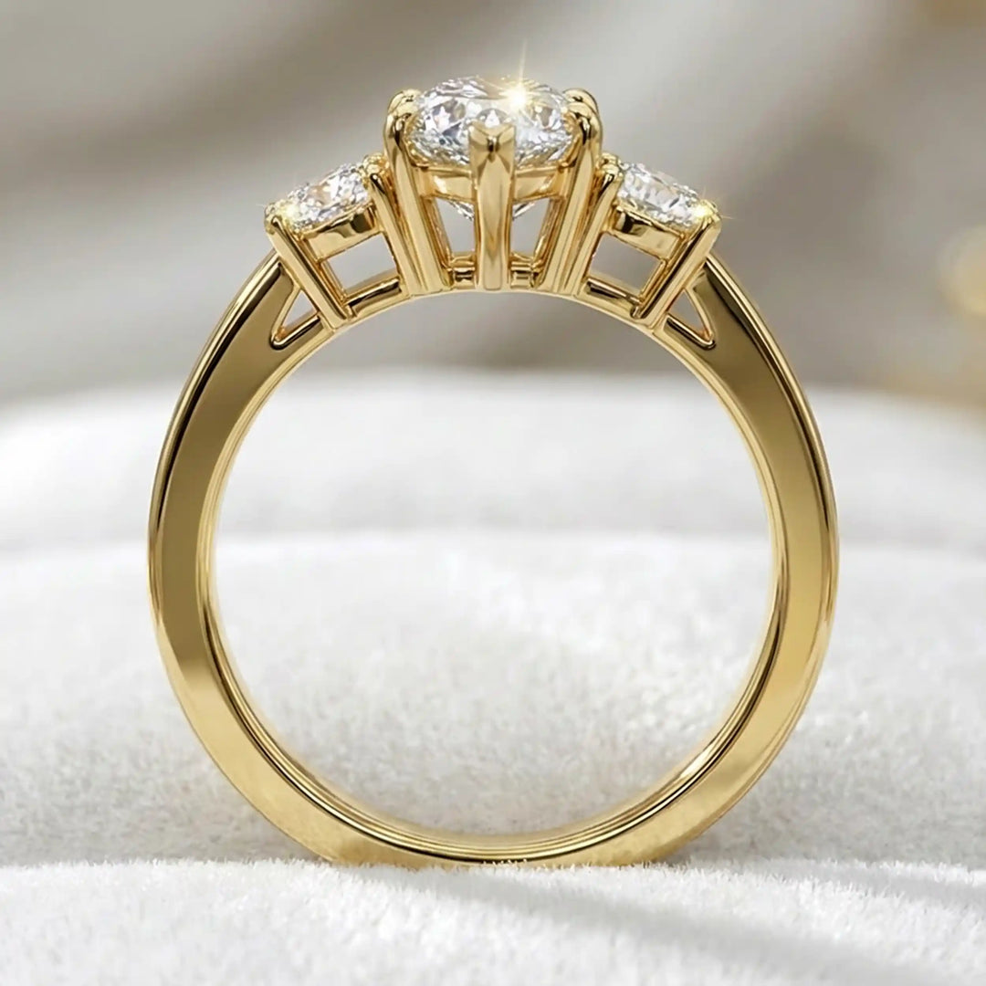 Marquise three-stone lab-grown diamond engagement ring displayed on soft fabric.
