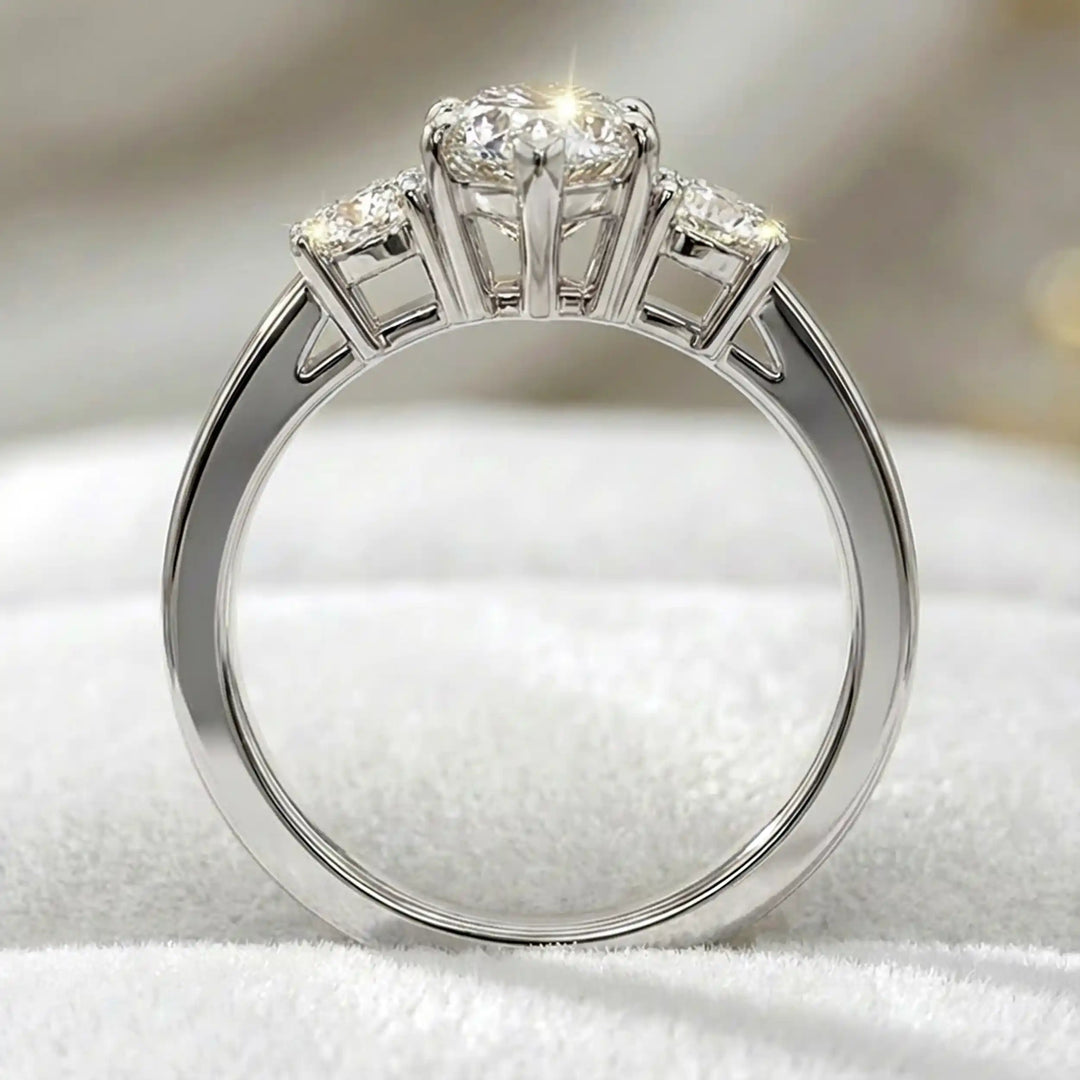 Marquise three-stone lab-grown diamond engagement ring displayed on soft fabric.

