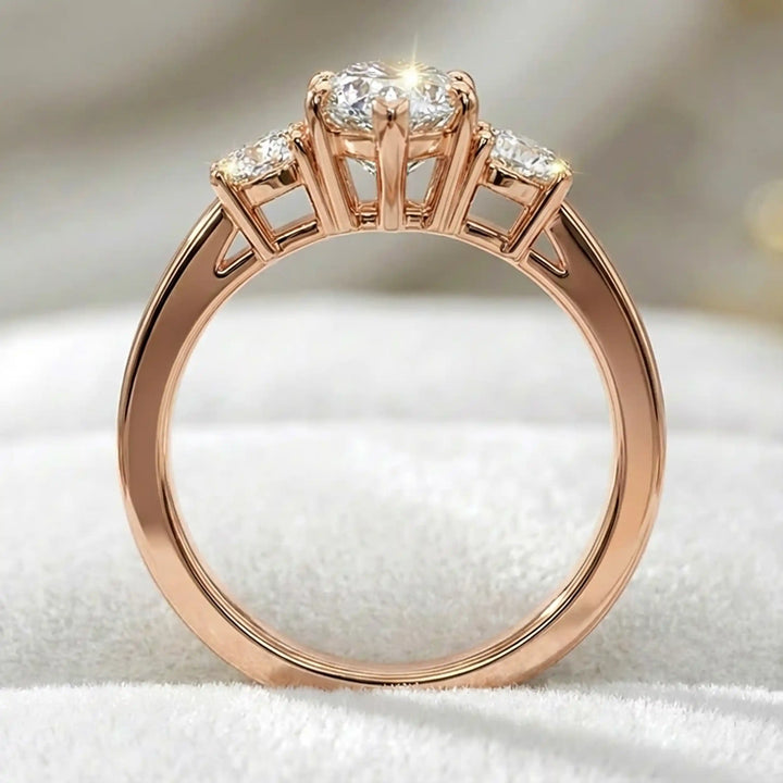 Marquise three-stone lab-grown diamond engagement ring displayed on soft fabric.
