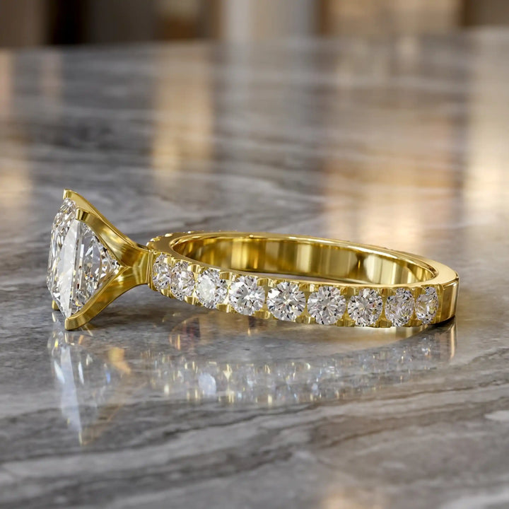 Princess cut lab diamond engagement ring with diamond band shown on marble display.