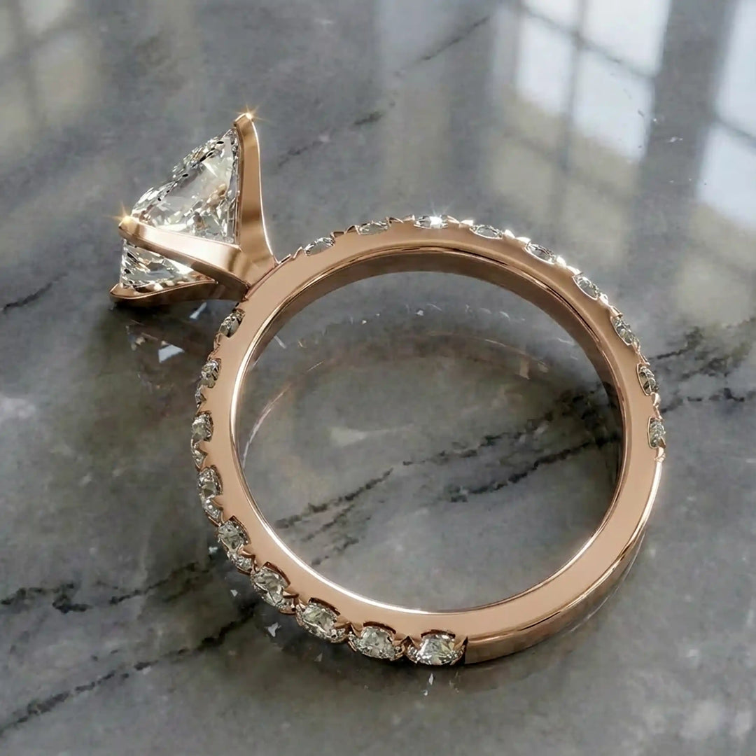 Princess cut lab diamond engagement ring with diamond band shown on marble display.