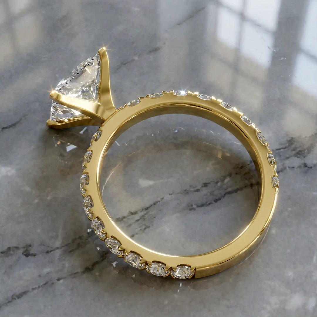 Princess cut lab diamond engagement ring with diamond band shown on marble display.