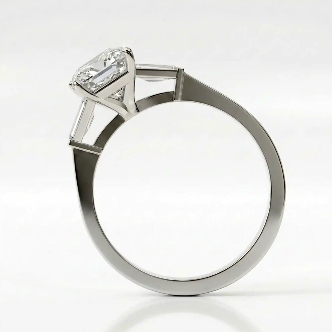 Radiant cut lab diamond three-stone engagement ring shown white surface.