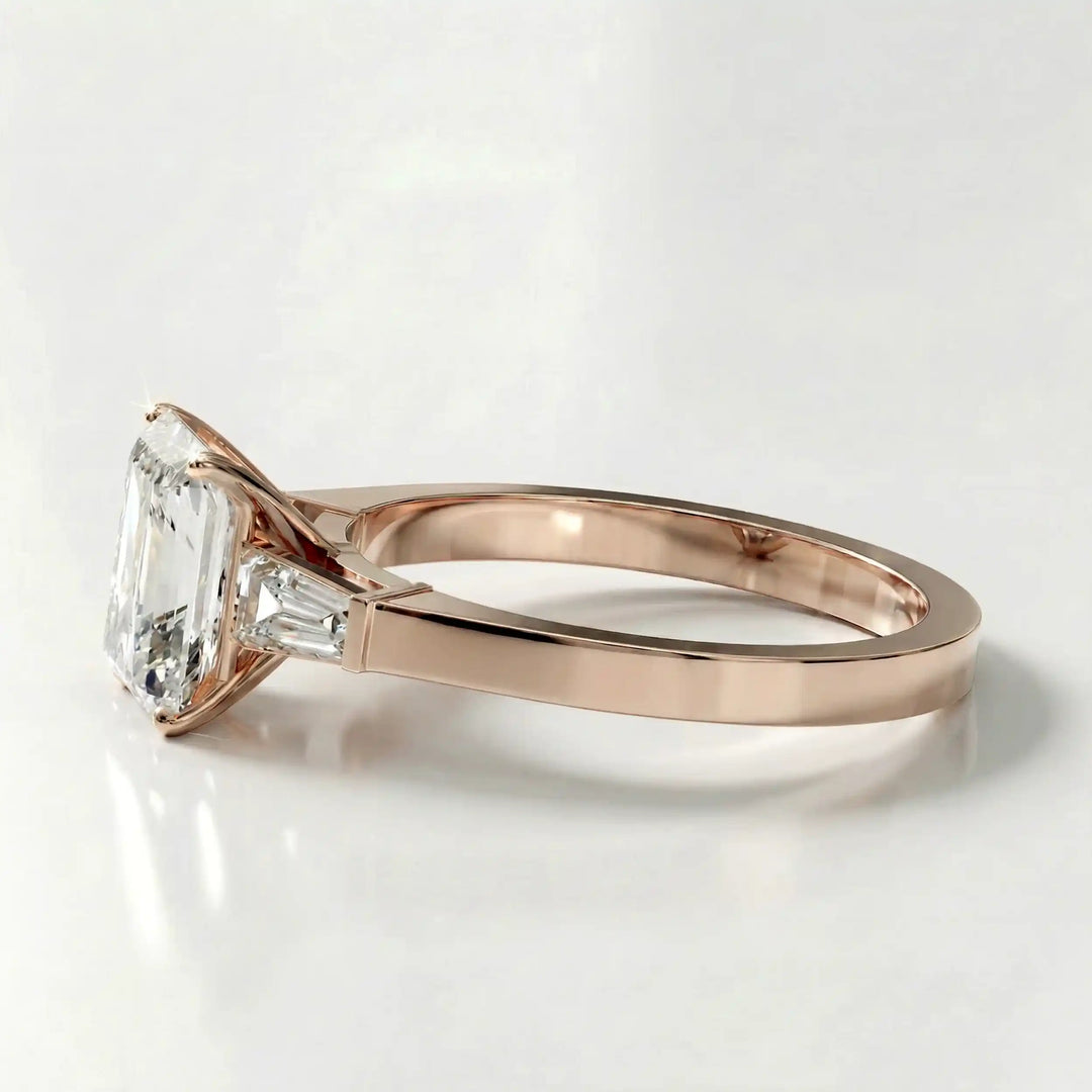 Radiant cut lab diamond three-stone engagement ring shown white surface.