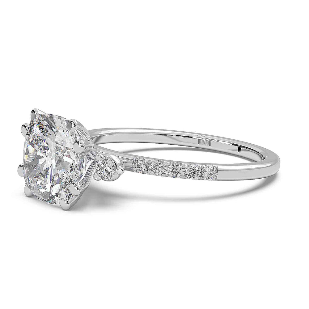 cushion-cut diamond engagement ring with pave-set diamond band and side stones