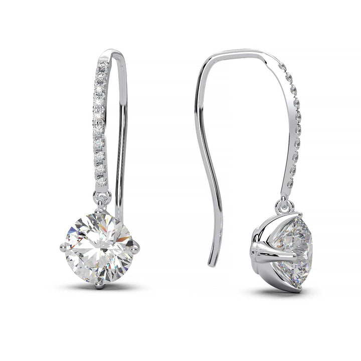 Dangling earrings with 1 ct round moissanite stones and small moissanite accents, set in 14k yellow gold.