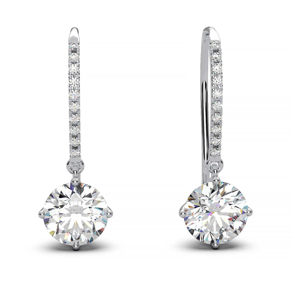 Dangling earrings with 1 ct round moissanite stones and small moissanite accents, set in 14k yellow gold.