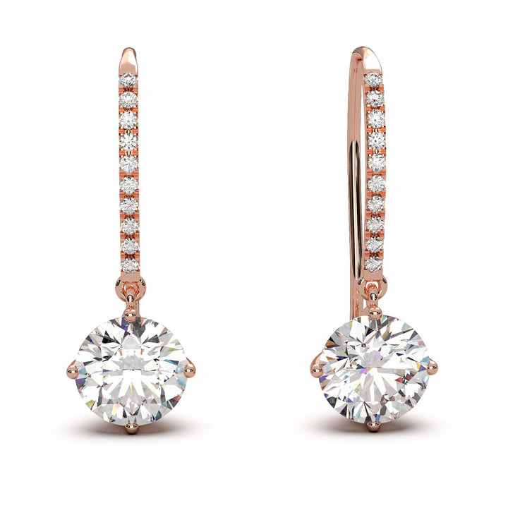 Dangling earrings with 1 ct round moissanite stones and small moissanite accents, set in 14k yellow gold.