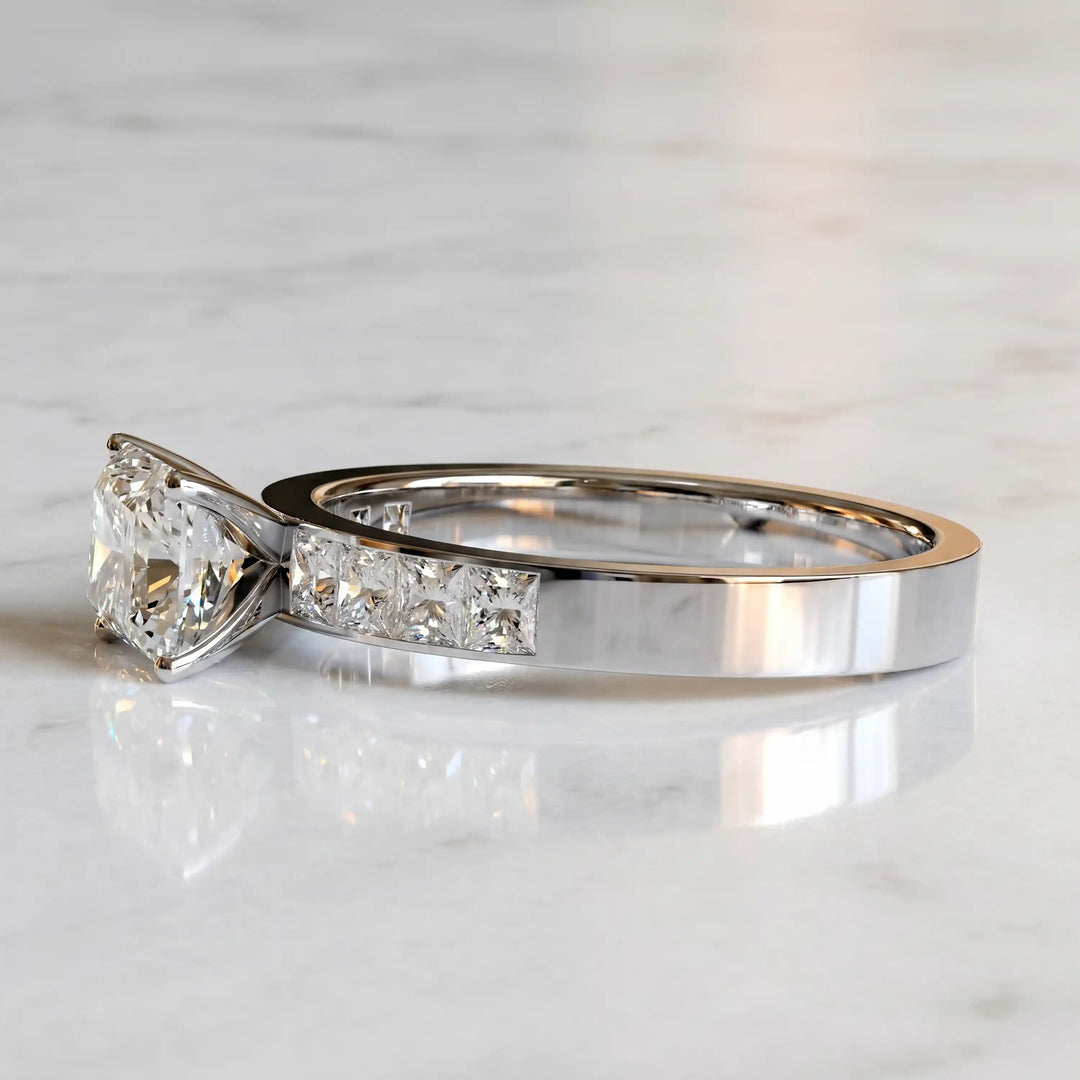 Radiant lab-grown diamond east-west engagement ring with channel-set princess side stones displayed on surface.