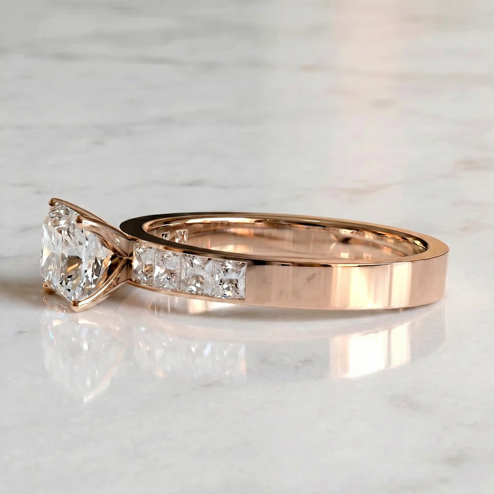 Radiant lab-grown diamond east-west engagement ring with channel-set princess side stones displayed on surface.