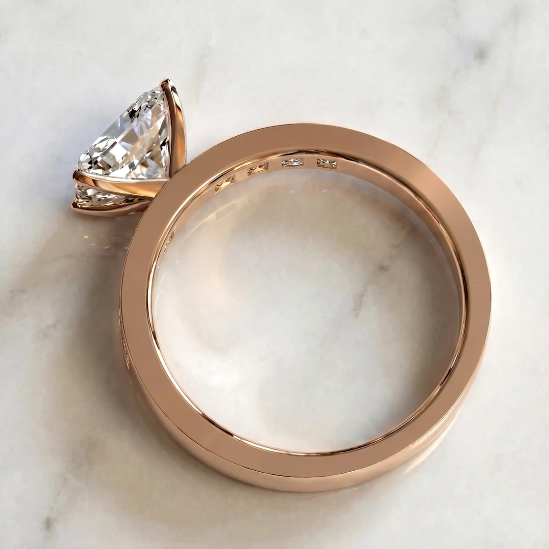 Radiant lab-grown diamond east-west engagement ring with channel-set princess side stones displayed on surface.