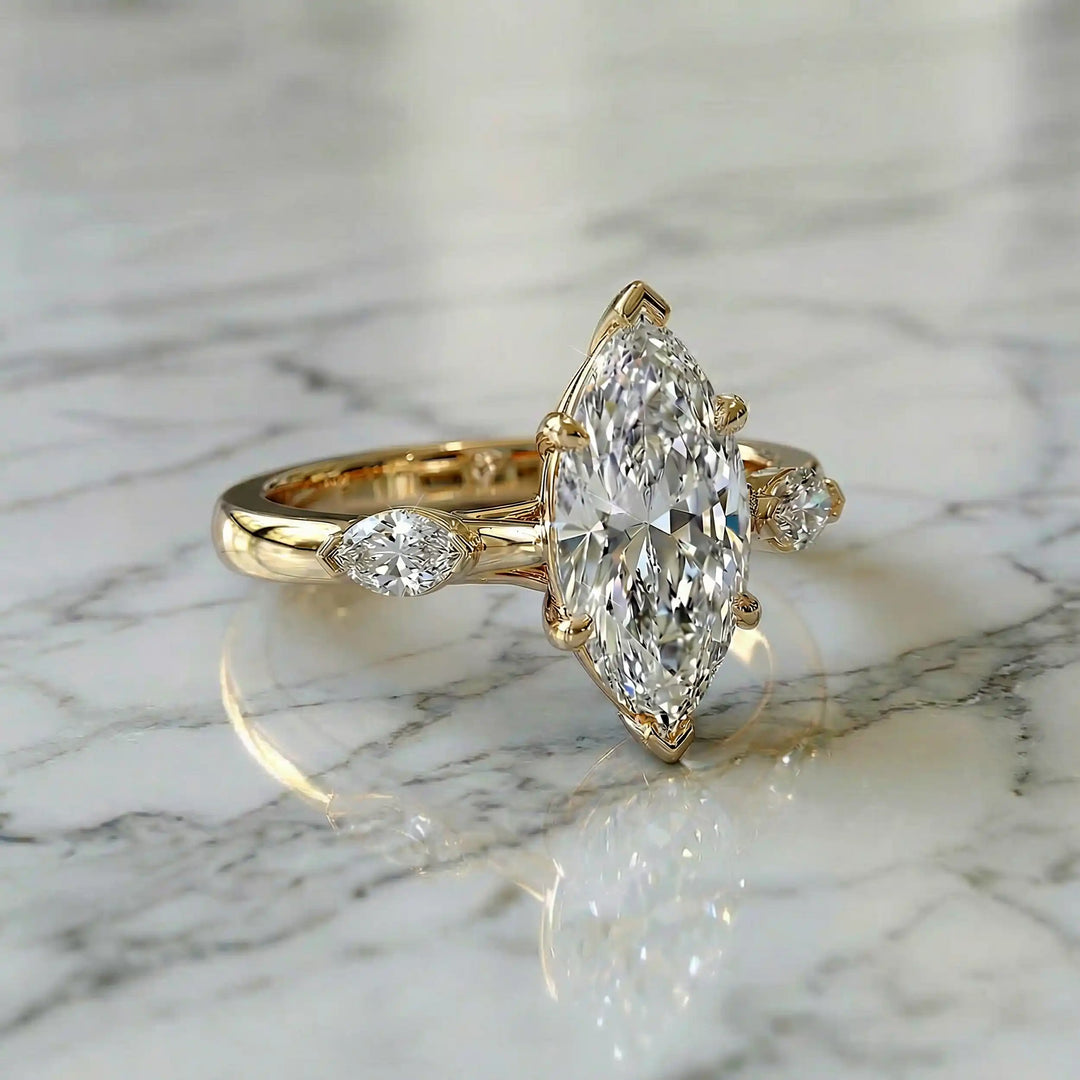 2.5 carat three stone marquise lab-grown diamond engagement ring displayed on marble surface.
