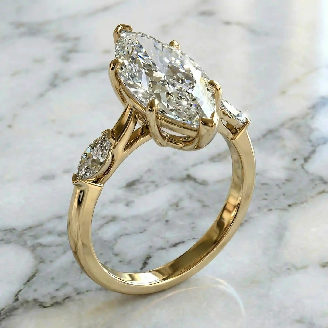 2.5 carat three stone marquise lab-grown diamond engagement ring displayed on marble surface.
