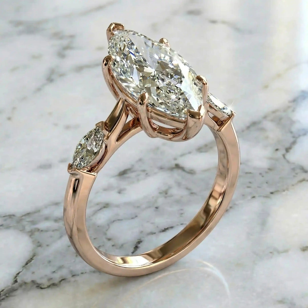 2.5 carat three stone marquise lab-grown diamond engagement ring displayed on marble surface.
