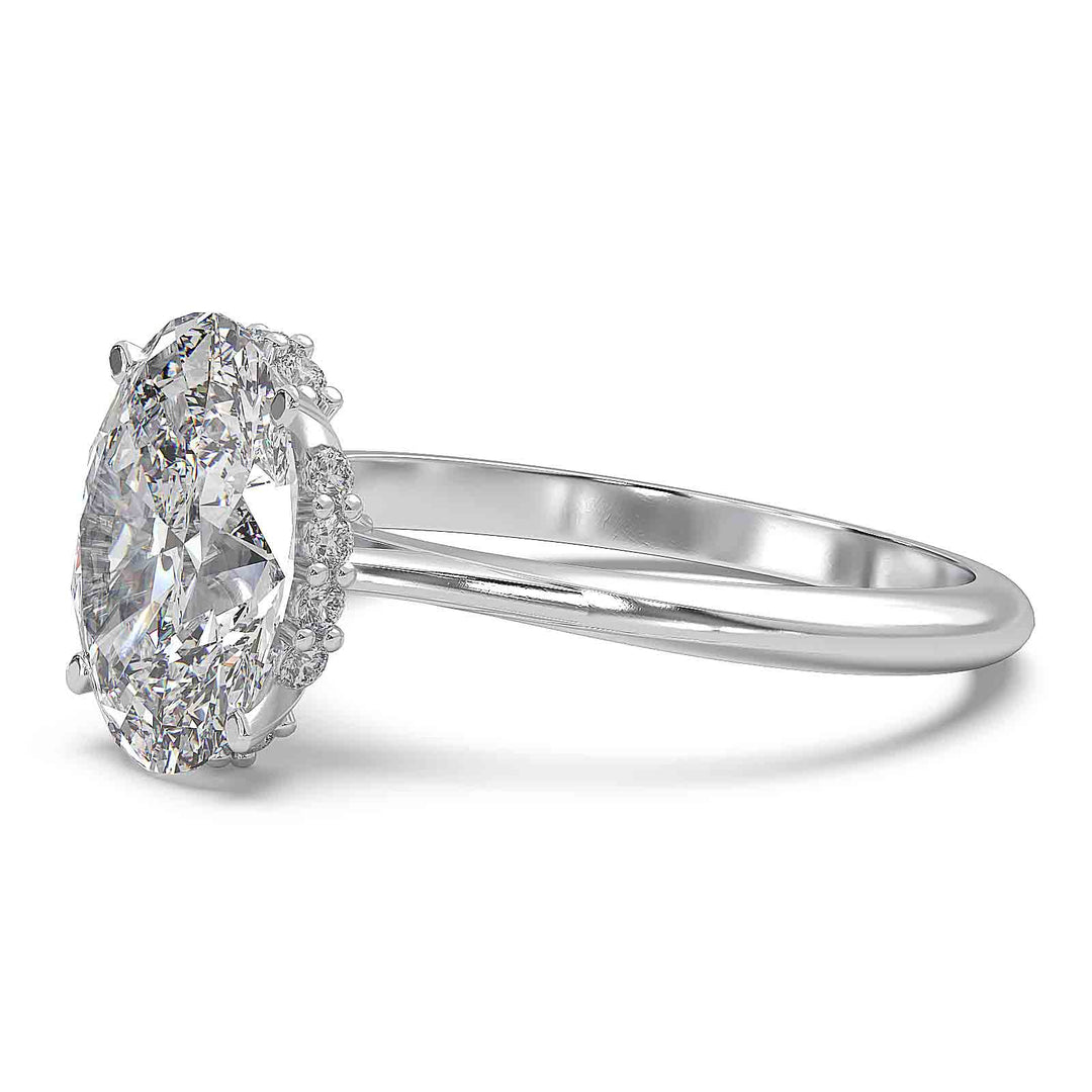 Oval diamond hidden halo engagement ring with cathedral setting and elegant prongs.