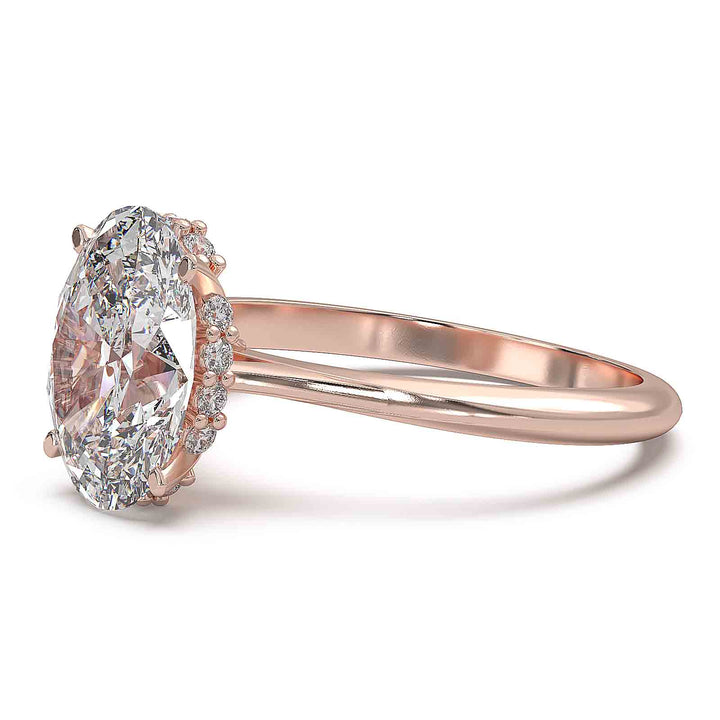 Oval diamond hidden halo engagement ring with cathedral setting and elegant prongs.