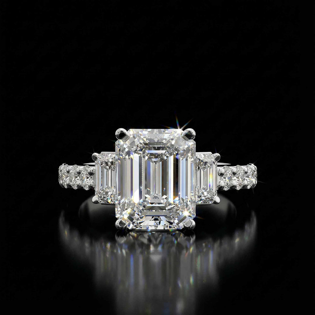 Emerald cut three stone diamond engagement ring with pavé band on display.
