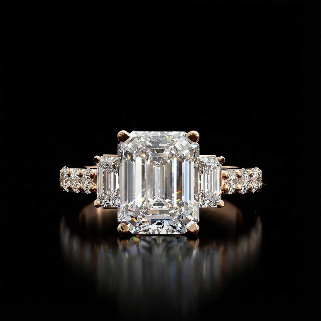 Emerald cut three stone diamond engagement ring with pavé band on display.
