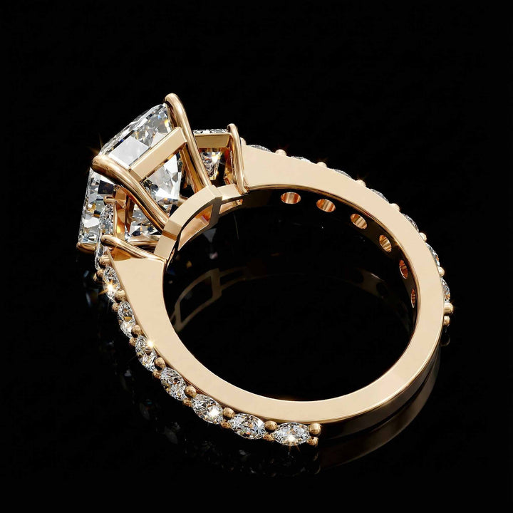 Emerald cut three stone diamond engagement ring with pavé band on display.