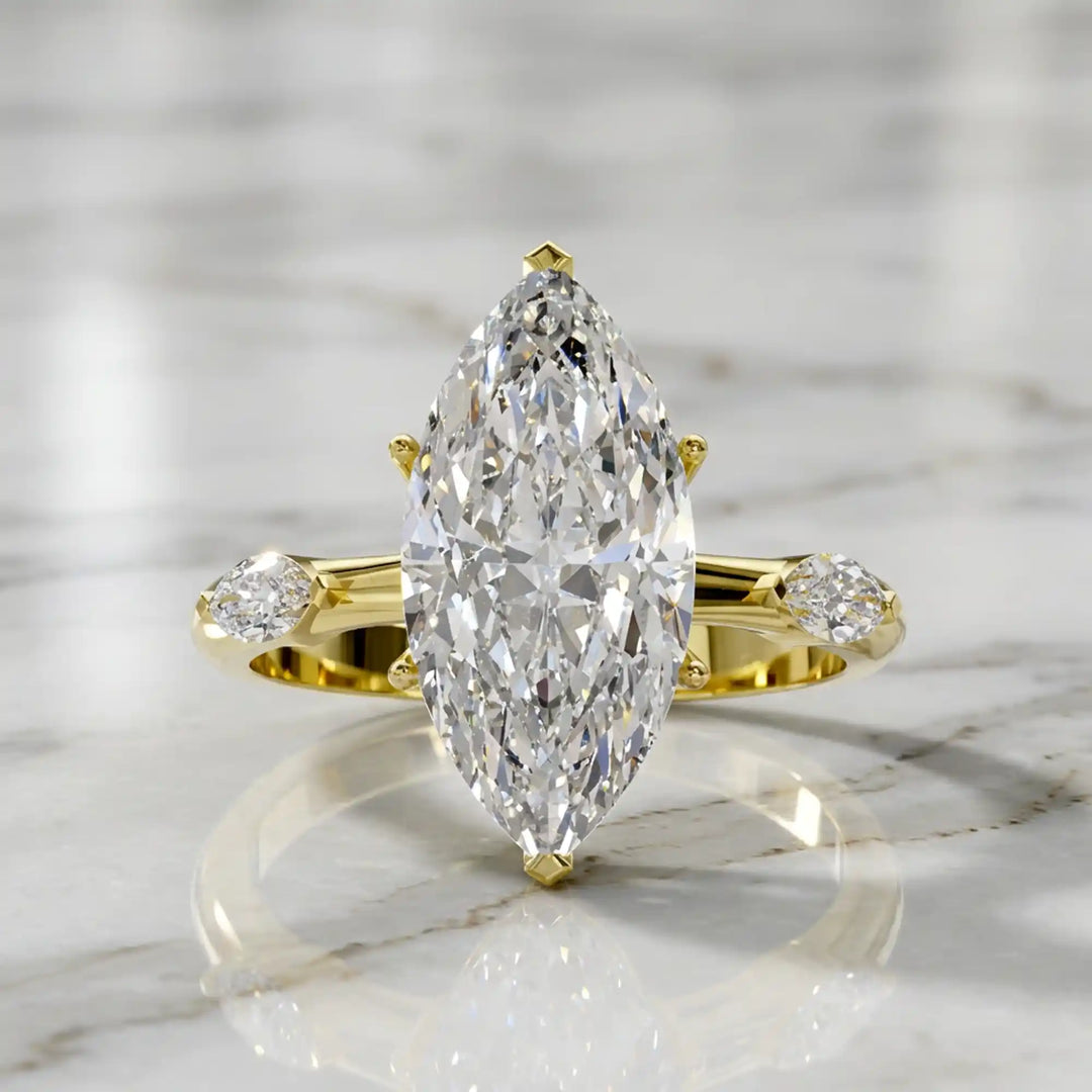 Marquise lab-grown diamond three-stone engagement ring with hidden halo shown on marble display.