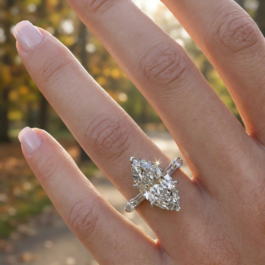 Marquise lab-grown diamond three-stone engagement ring with hidden halo shown on hand.