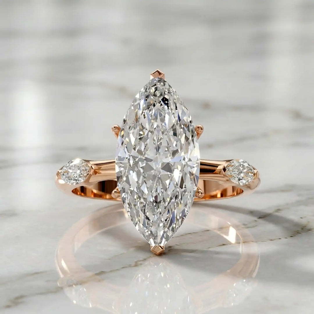 Marquise lab-grown diamond three-stone engagement ring with hidden halo shown on marble display.