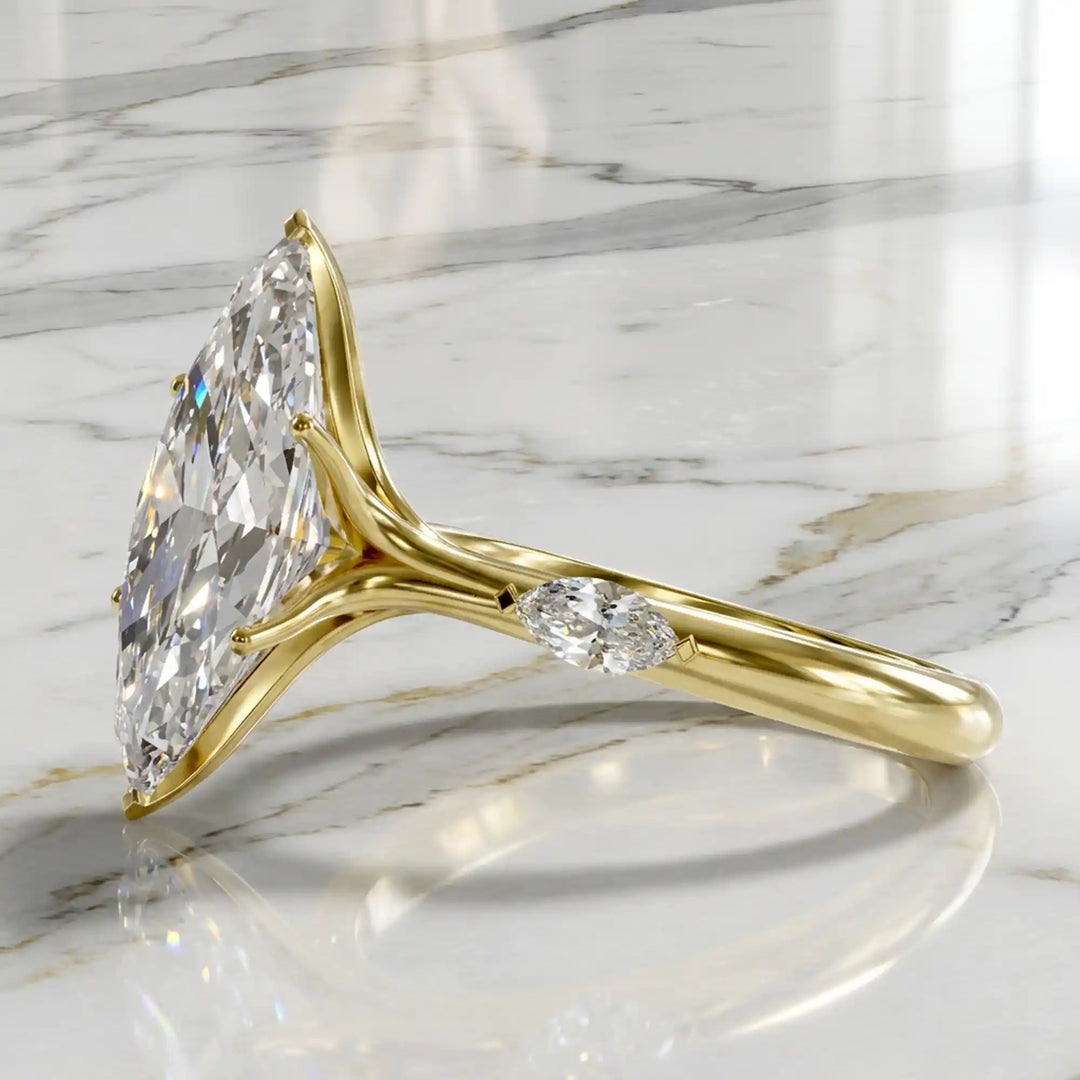 Marquise lab-grown diamond three-stone engagement ring with hidden halo shown on marble display.