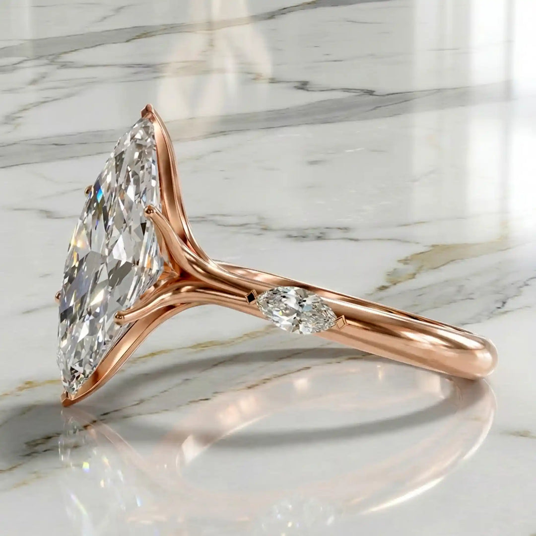 Marquise lab-grown diamond three-stone engagement ring with hidden halo shown on marble display.