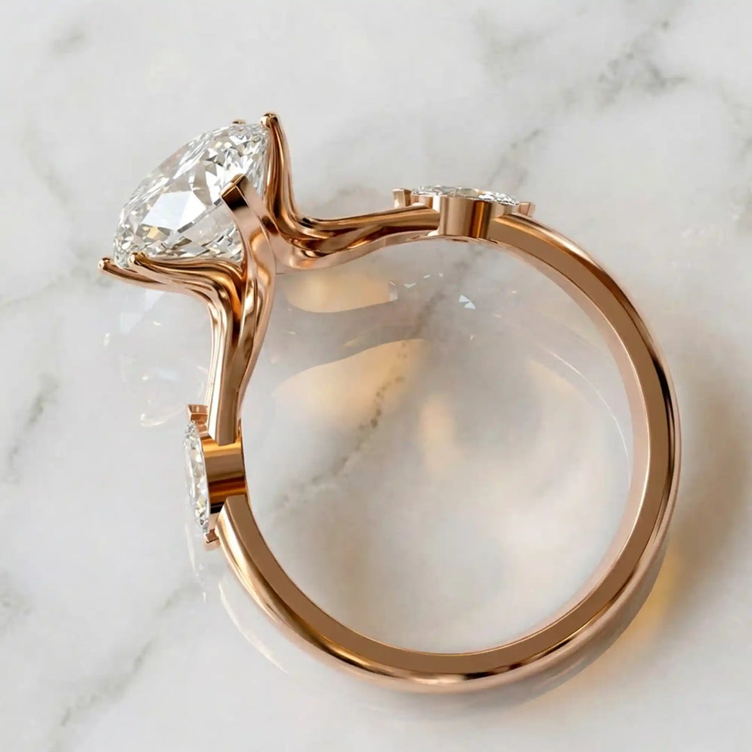 Marquise lab-grown diamond three-stone engagement ring with hidden halo shown on marble display.