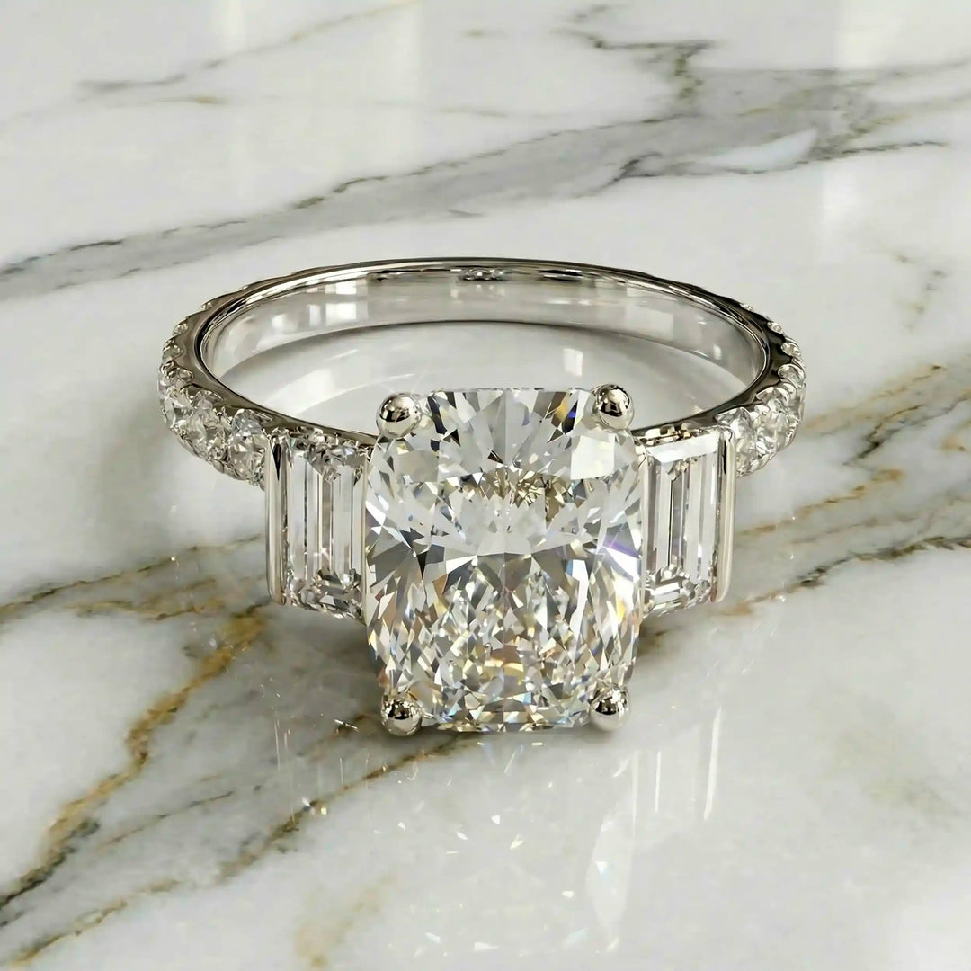 Elongated cushion three stone lab-grown diamond engagement ring displayed on marble surface.