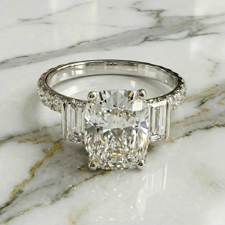 Elongated cushion three stone lab-grown diamond engagement ring displayed on marble surface.