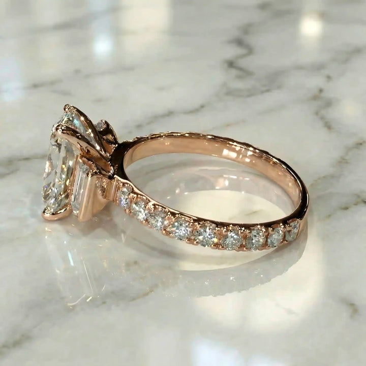 Elongated cushion three stone lab-grown diamond engagement ring displayed on marble surface.
