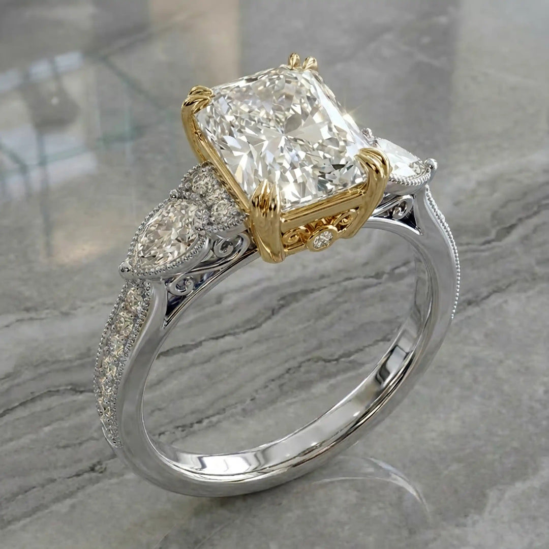 Radiant lab-grown diamond engagement ring with pear side stones displayed on ring stand.

