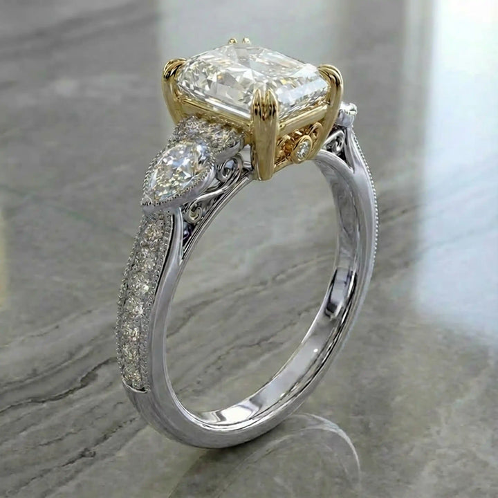 Radiant lab-grown diamond engagement ring with pear side stones displayed on ring stand.
