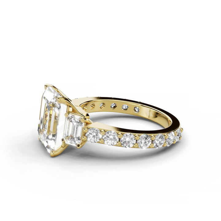 Emerald cut diamond three-stone engagement ring in yellow gold.