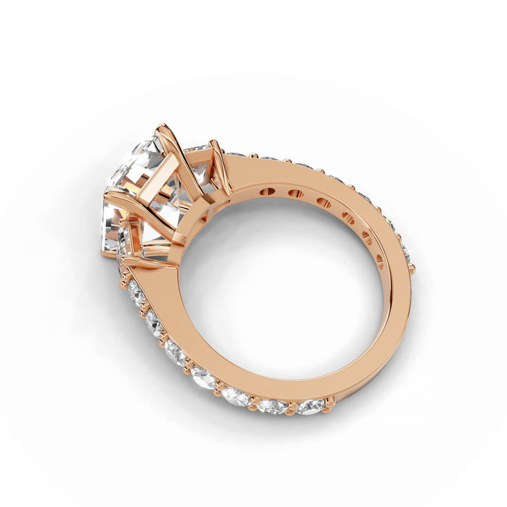 Emerald cut diamond engagement ring with three stones in rose gold.
