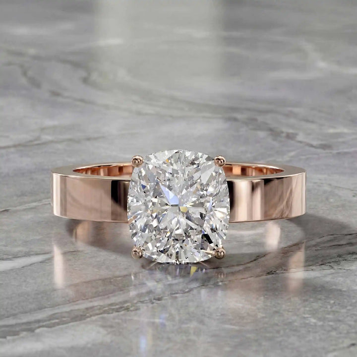 Elongated cushion lab grown diamond solitaire ring on wide flat band shown on display.