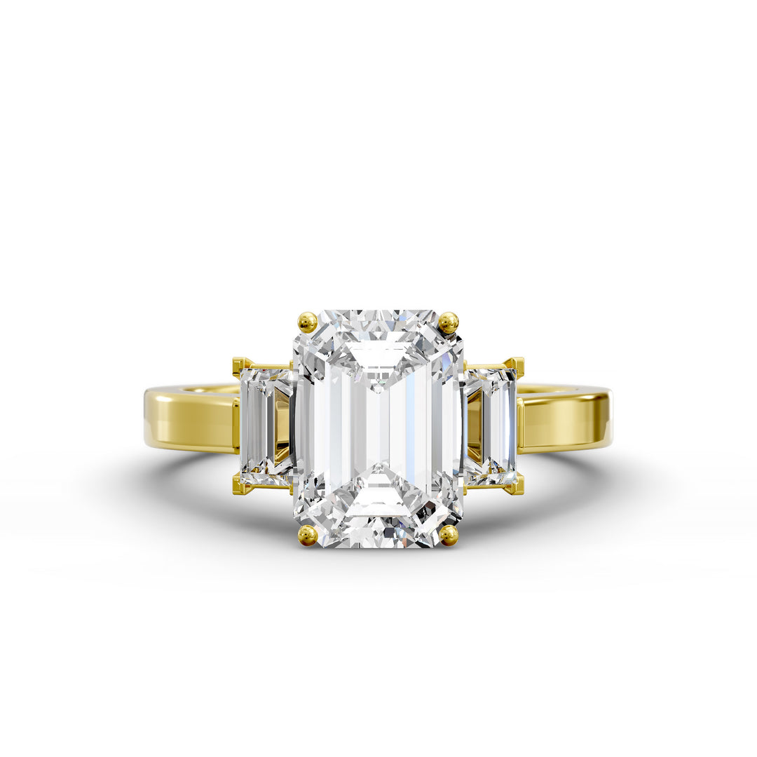 Emerald-cut three-stone diamond engagement ring with matching emerald side stones shown in studio lighting.