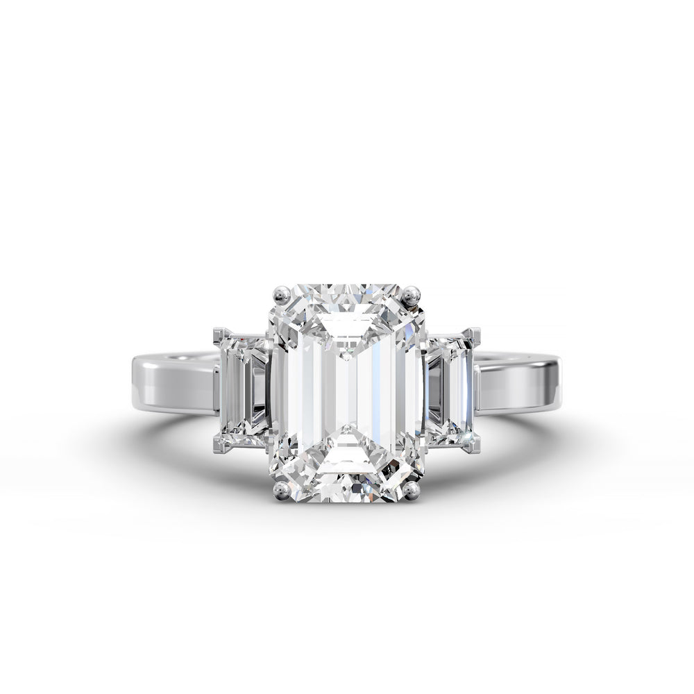 Emerald-cut three-stone diamond engagement ring with matching emerald side stones shown in studio lighting.
