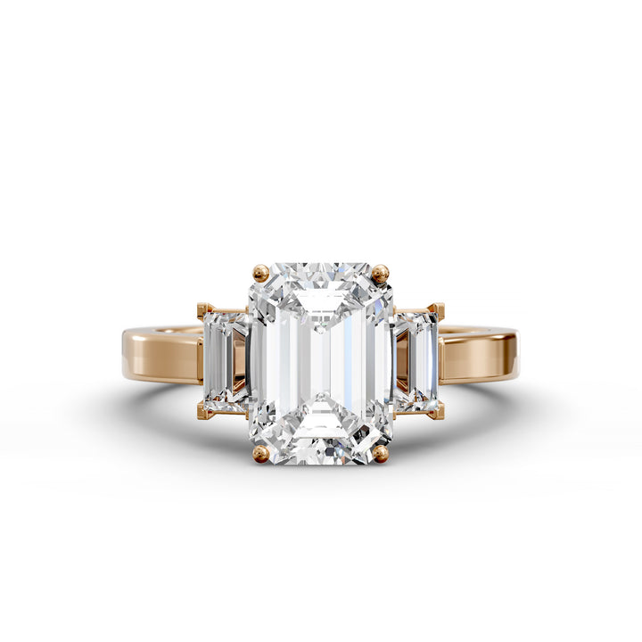 Emerald-cut three-stone diamond engagement ring with matching emerald side stones shown in studio lighting.