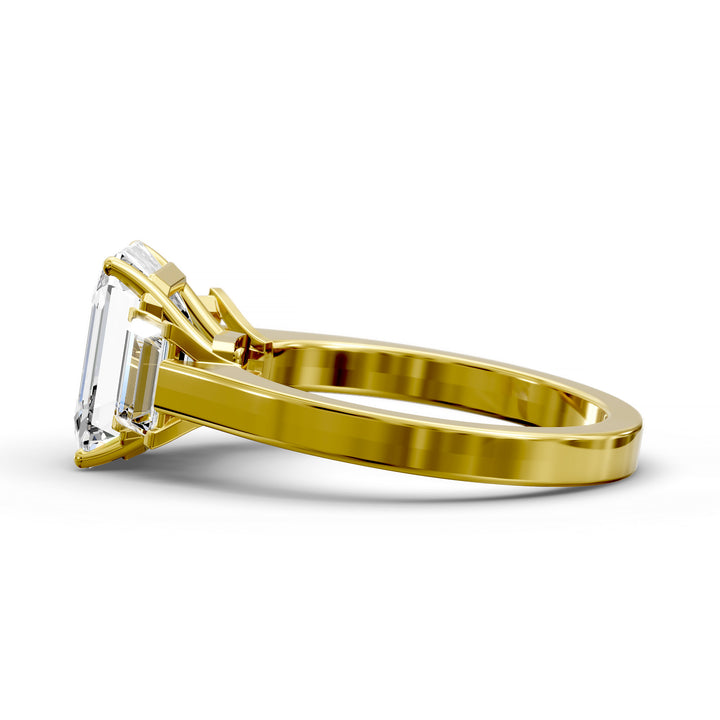 Emerald-cut three-stone diamond engagement ring with matching emerald side stones shown in studio lighting.