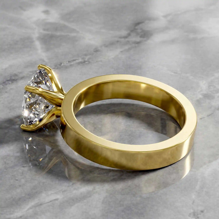 Elongated cushion lab grown diamond solitaire ring on wide flat band shown on display.