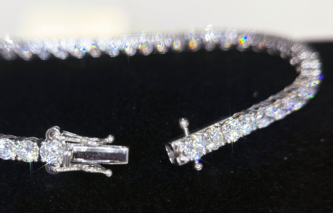 Open tennis bracelet clasp on a dark surface