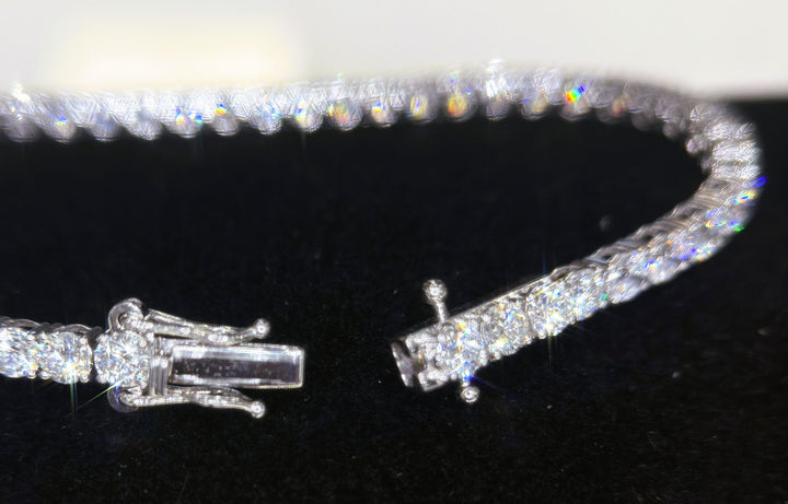Open tennis bracelet clasp on a dark surface