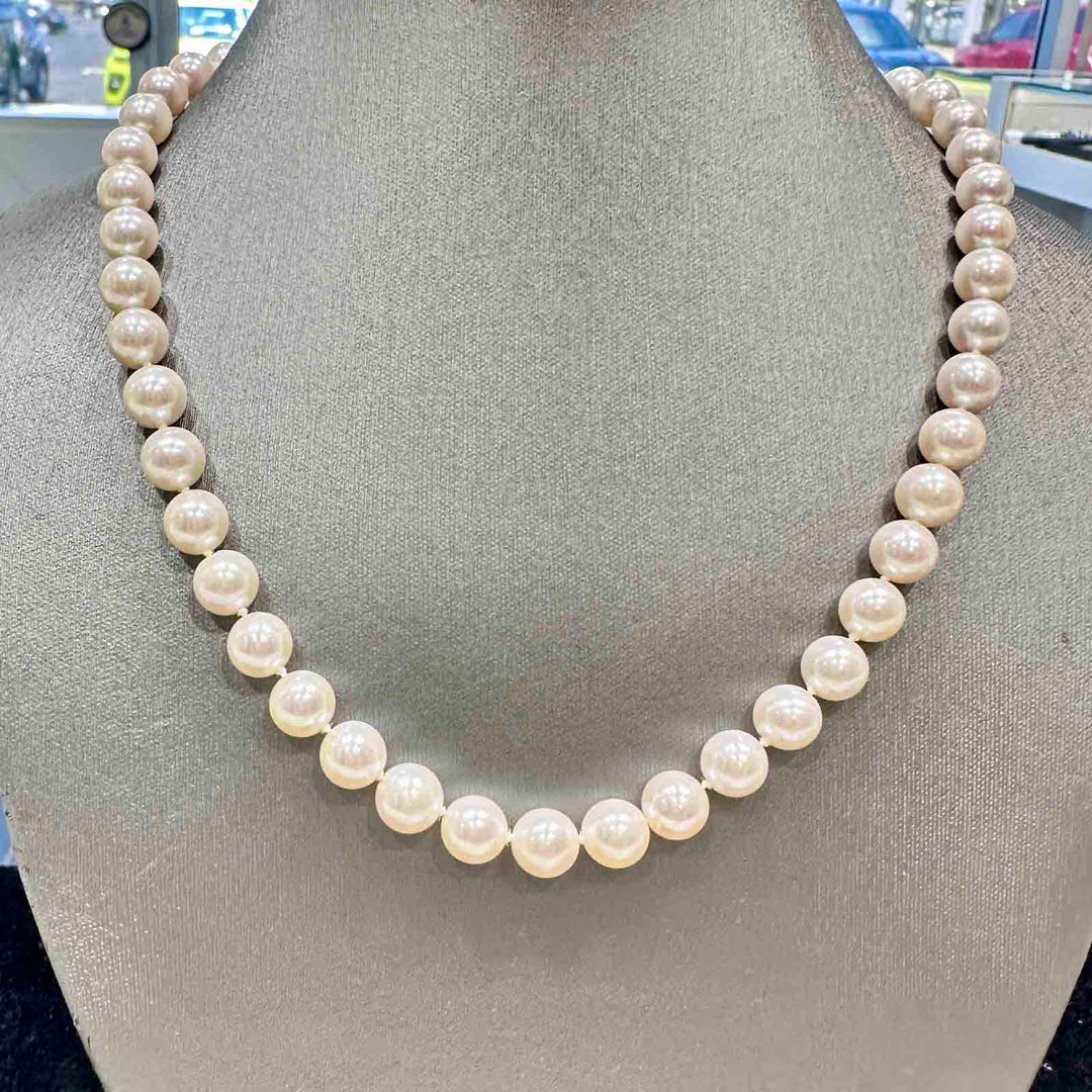 Freshwater pearl necklace with 8.9-7.9mm high luster white pearls and a pinkish overtone, featuring a 14k gold clasp.