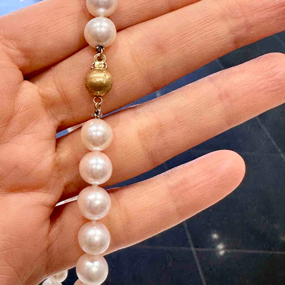 Freshwater pearl necklace with 8.9-7.9mm high luster white pearls and a pinkish overtone, featuring a 14k gold clasp.