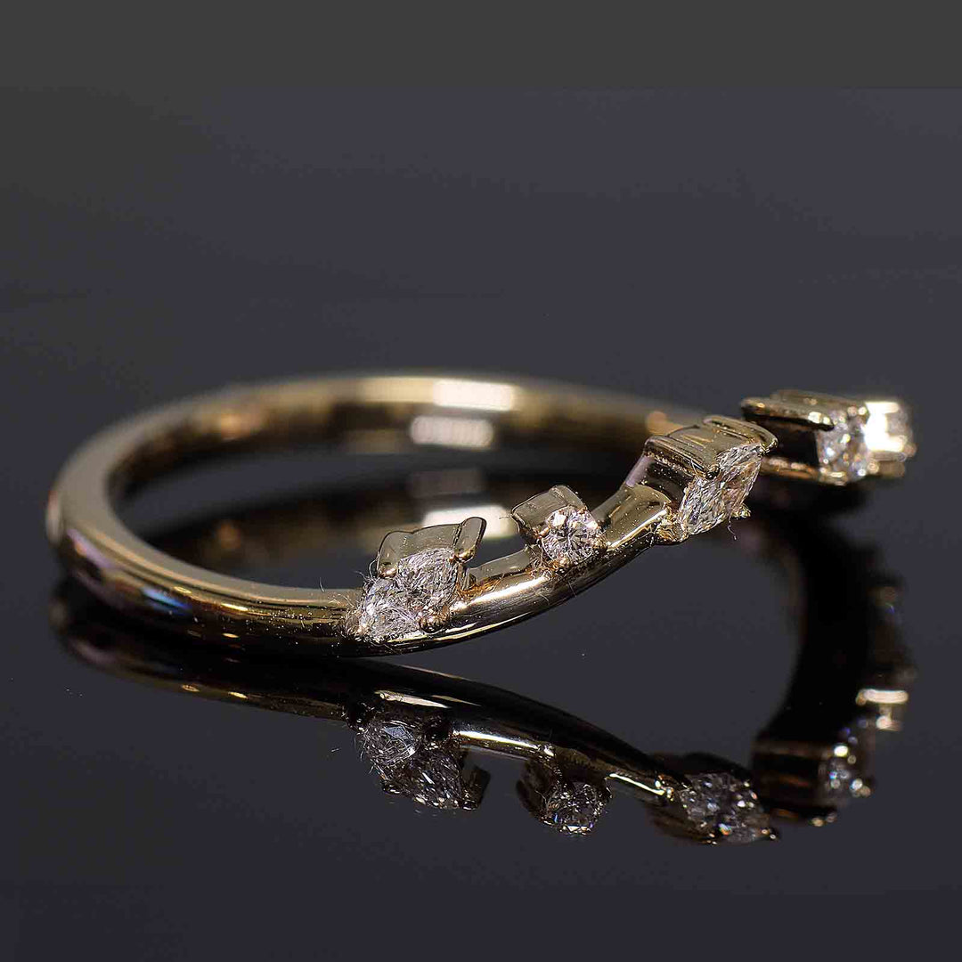 Curved wedding band with lab-grown round and marquise diamonds in shared prongs, open design.